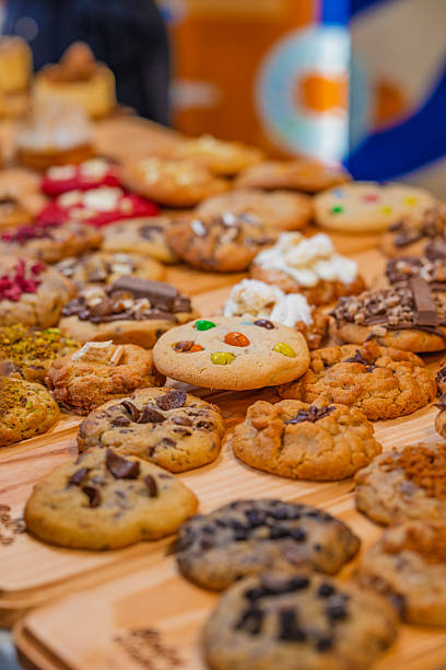 “Assorted artisanal desserts and pastries displayed on wooden table in modern bakery”