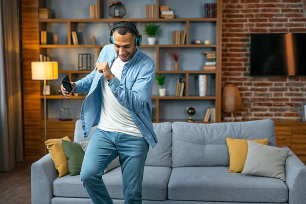 istock Young man in headphones dancing at home 2241767668