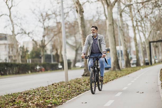 istock Man Riding Bike Down Bicycle Lane 2241769667