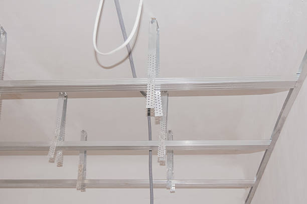 Metal frame of suspended ceiling, galvanised profile and perforated hangers prepared for drywall installation during interior construction