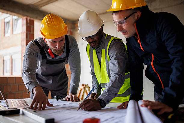 istock Team of engineers and builders discusses a construction plan inside an unfinished building 2241780381