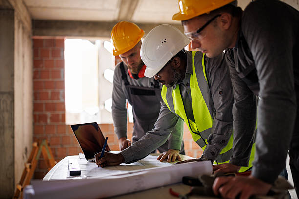 istock Team of engineers and builders discusses a construction plan inside an unfinished building 2241780397