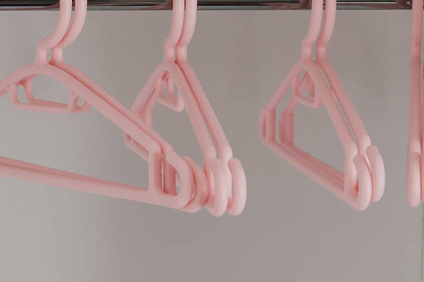 istock Plastic soft pink hangers for children's clothes in the wardrobe. 2241782607