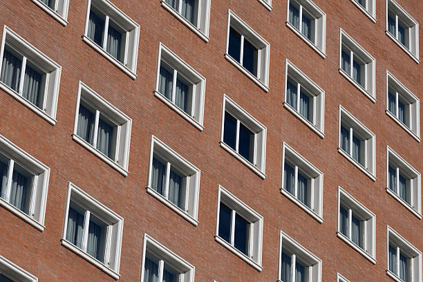 Madrid. Spain. Building an abstract pattern with numerous rectangular windows creating a modern architectural design against a brick wall, showcasing urban density and repetitive structure