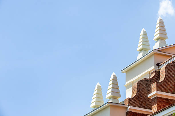 Roofs of a vintage building with white painted concrete pyramidal ornaments