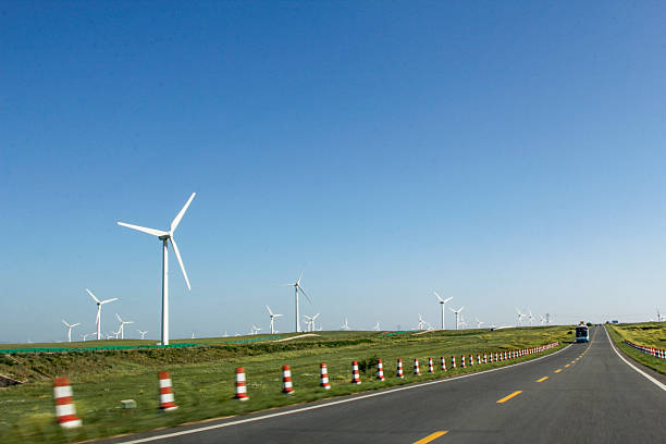 istock Road with wind turbines in the background under clear blue sky 2241791371