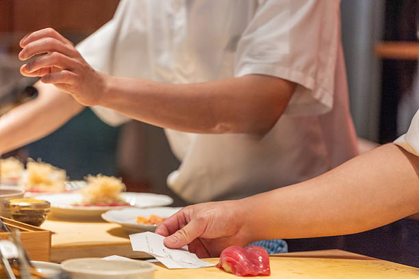 istock Chef preparing sushi with fresh ingredients on wooden countertop in restaurant 2241791925