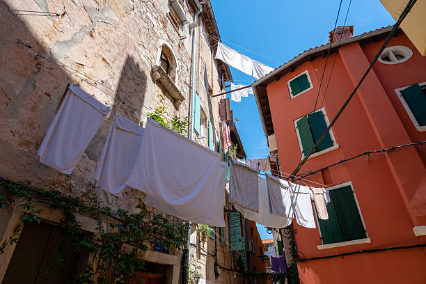 istock Sunlit laundry hangs between rustic stone walls and a terracotta house with green shutters, capturing the everyday rhythm and warmth of life in a quiet old-town 2241794239