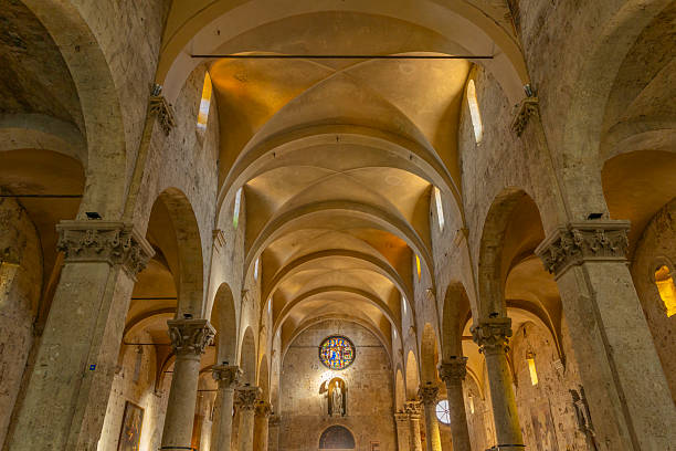 Church interior featuring stone columns, pointed arches, and a vaulted ceiling with light entering