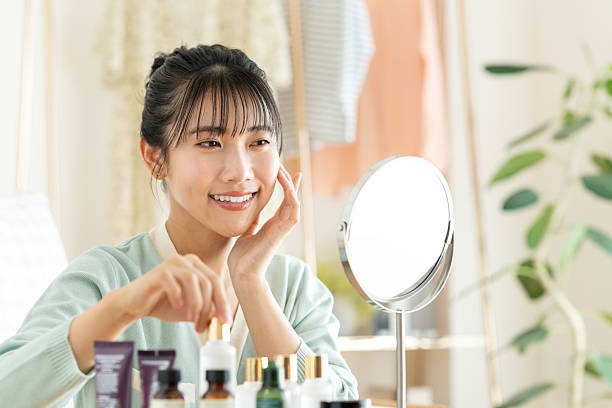 istock Young woman applying makeup looking in the mirror 2241798249