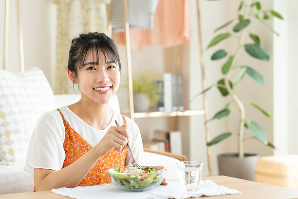 istock Young woman eating salad 2241798615