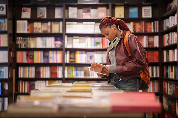 istock Woman reading a book in a bookstore aisle 2241799362