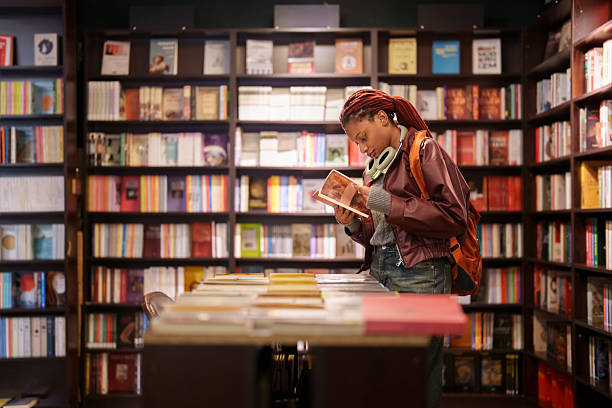 istock Woman reading a book in a bookstore aisle 2241799379