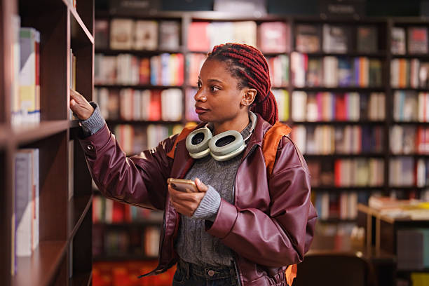 istock Young woman browsing books in a bookstore 2241799537