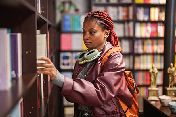 istock Young woman browsing books in a bookstore 2241799735