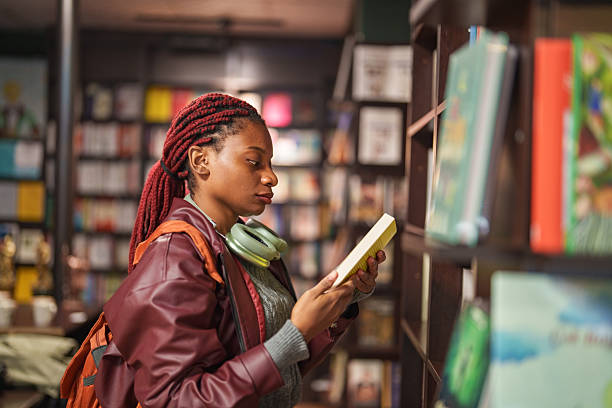 istock Young woman reading in a bookstore 2241800258