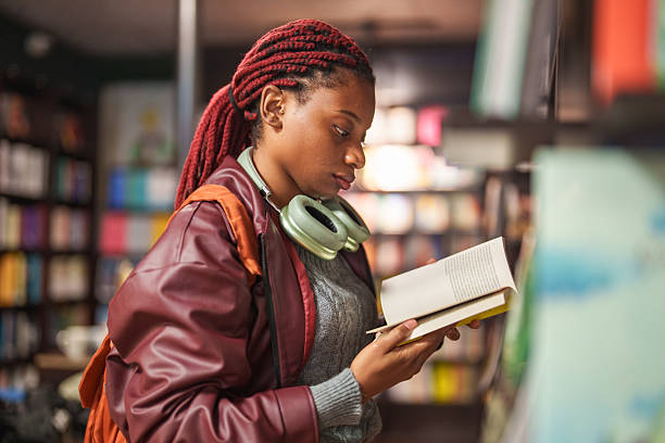 istock Young woman reading in a bookstore 2241800260