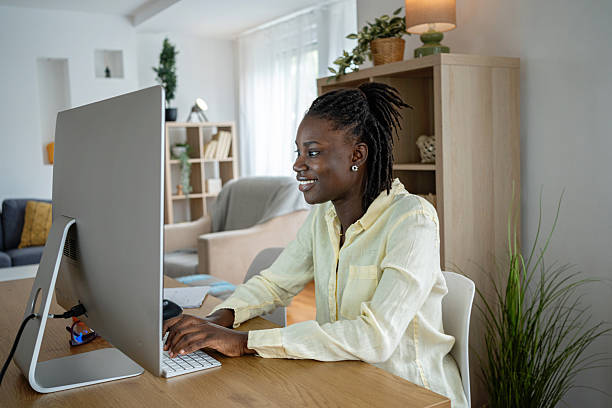 istock Smiling black woman working on her computer from home, typing on a keyboard 2241801494