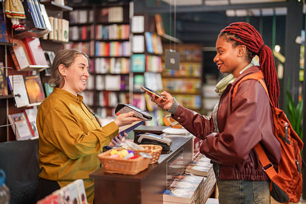 istock Customer paying with smartphone at bookstore counter 2241801896