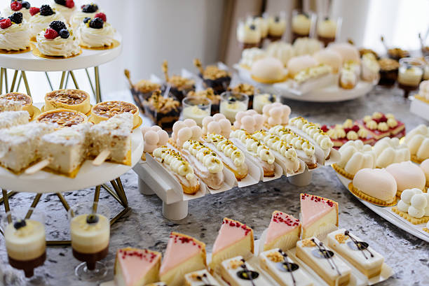 istock A beautiful assortment of delicate pastries, including cupcakes, macarons, and eclairs, elegantly displayed on a multi-tiered white stand for a wedding candy bar or festive celebration 2241803926