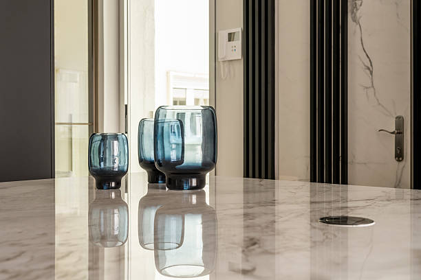 istock Decorative blue glass vases on white marble top where they are reflected 2241806200