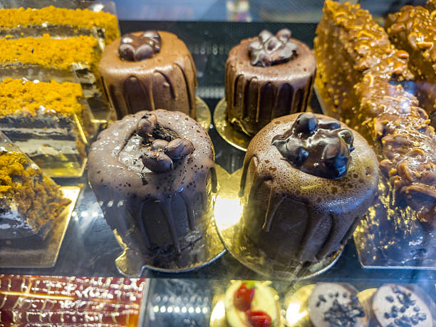 Different cakes with fresh fruits and berries in store window. Delightful array of colorful pastries and desserts displayed in a bakery.