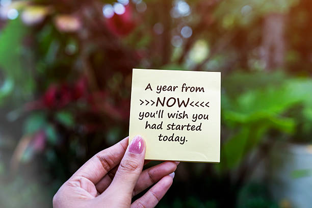 istock Hand holding a paper note with quotes A year from now you'll wish you had started today. 2241814433