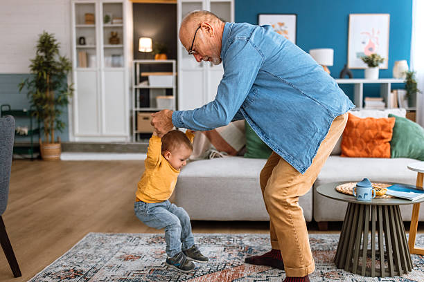 istock Senior man having fun with his cute grandson while dancing in living room. 2241819442