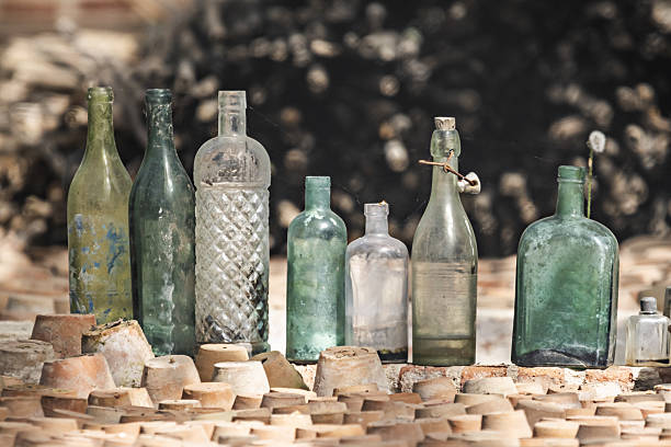 istock Antique glass bottles stacked next to terracotta pots 2241822507