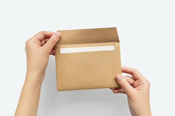 istock Hands opening a brown kraft paper envelope with a blank white card inside 2241822560