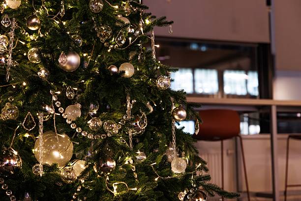 istock Sparkling Christmas tree adorned with silver ornaments and glowing lights in a cozy indoor setting 2241822562