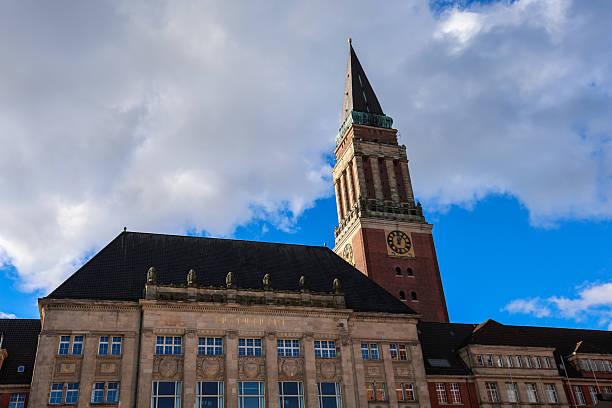Kiel, Germany - 17. October 2025: Kiel city hall tower with a clock showing time and traditional architecture under a cloudy blue sky
