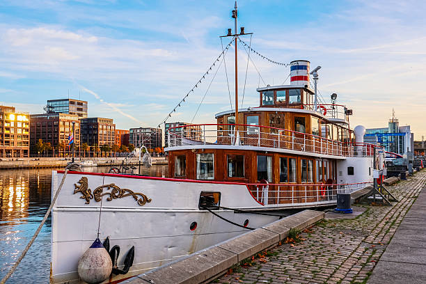 Kiel, Germany - 17. October 2025: Classic boat with wooden details moored at a cobblestone quay in Kiel