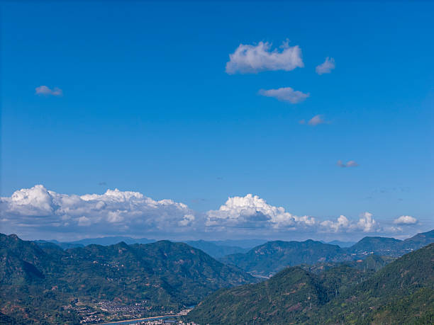 Scenic mountain range under clear blue sky, lush greenery, serene atmosphere, ideal for nature photography or travel promotions.