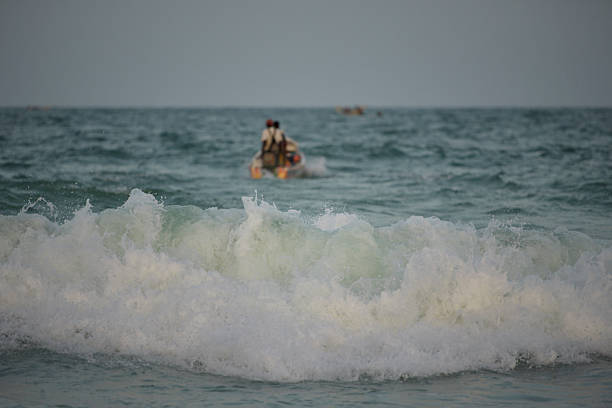 Nouakchott. Mauritania. October 03, 2021. Struggling with the waves of the surf, fishermen daily sail out on special wooden boats with a motor for several days in the open Atlantic Ocean for fishing.