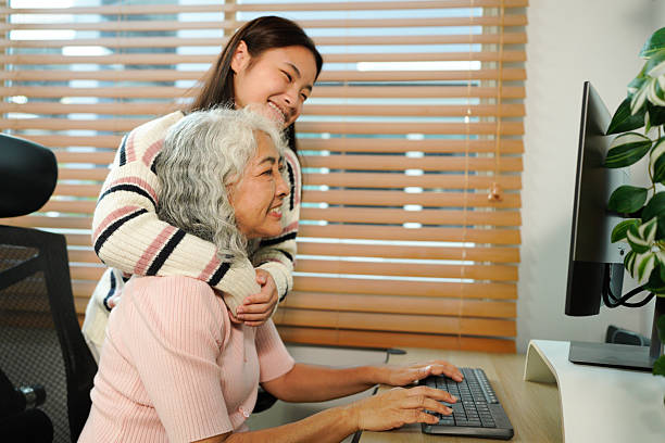 istock granddaughter teaches her grandmother work with computer at home 2241831022