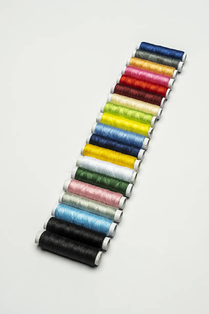 a diagonal strip of spools of colored sewing threads