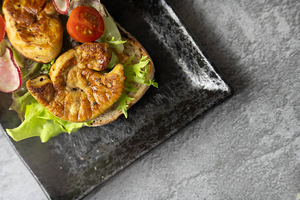 Exquisite Close-up of Gourmet Foie Gras on Toasted Bread, Elegantly Garnished with Fresh Herbs, Creating a Luxurious and Tempting Fine Dining Appetizer