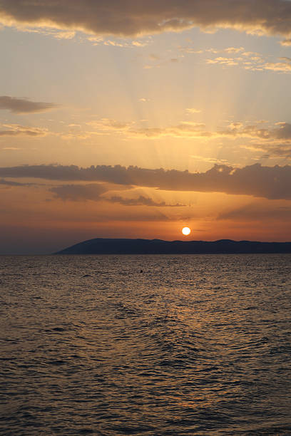 istock Bright sunset at sea, orange sky and sunrays over the sea 2241836889