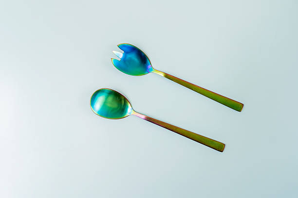 istock Set of iridescent metal salad spoons on a smooth surface 2241839236