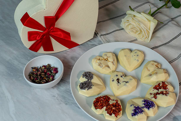 istock Heart-shaped chocolates with floral decoration on marble table with rose and gift box 2241841421