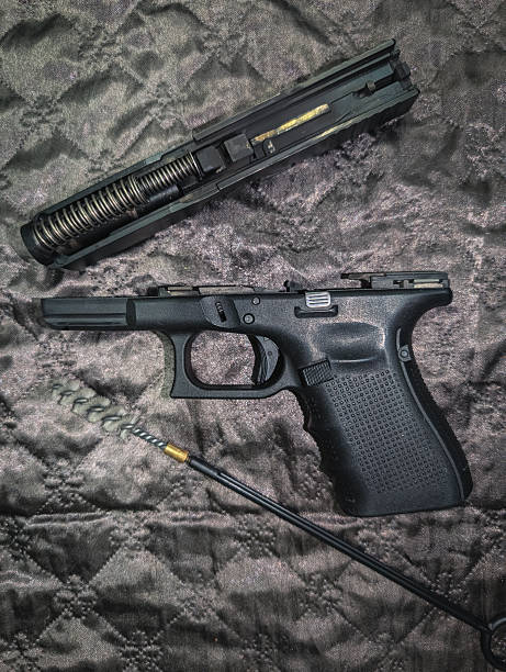 istock A modern semi-automatic pistol is field-stripped for routine cleaning and maintenance, with its slide, frame, and bore brush laid out 2241847071
