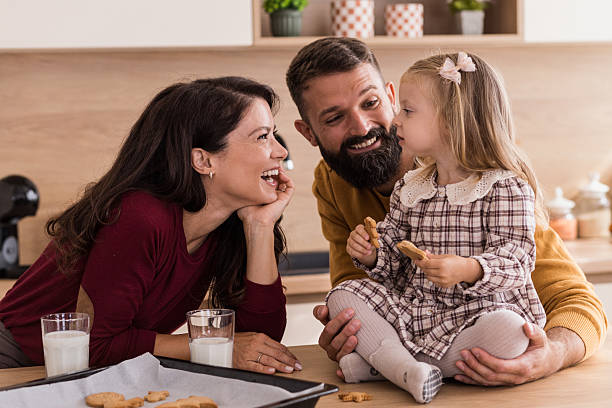 istock Girl Eating Cookie While Parents Smile 2241851902