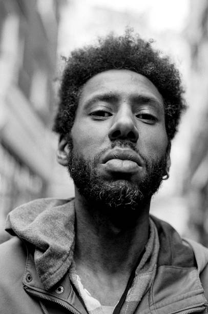 istock Young man posing in urban setting, grainy black and white portrait 2241854652
