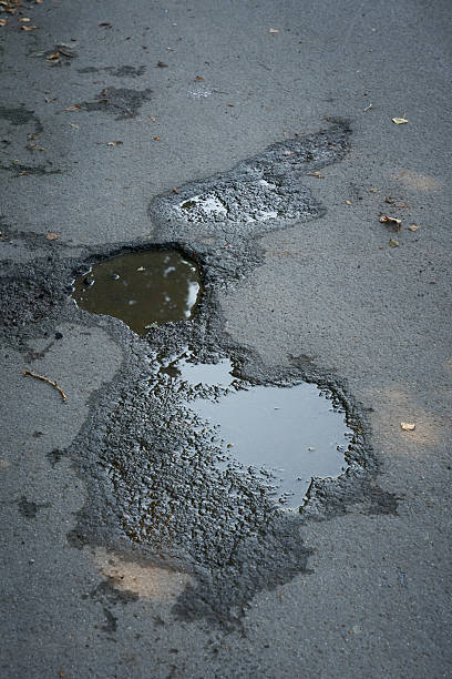istock pothole in the asphalt of a road 2241865680