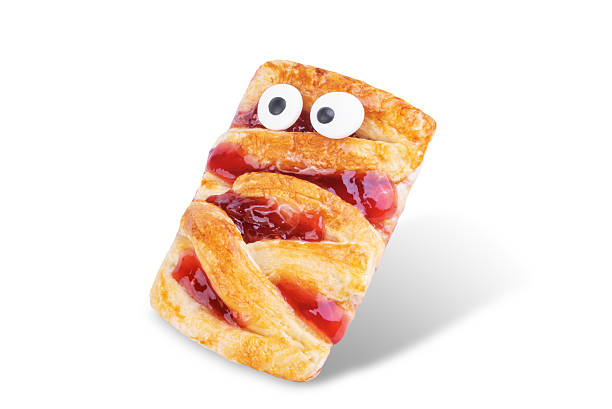 Puffed cakes with raspberry jam in the form of mummy for Halloween holidays on a white isolated background. toning