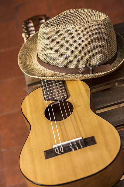 istock A guitar resting on a wooden box and a straw hat and clay flooring 2241878042