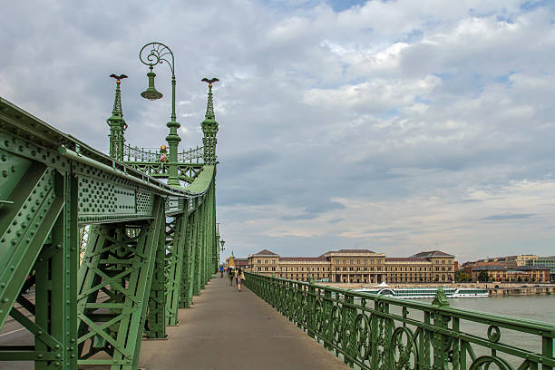 Budapest, Hungary: Liberty Bridge, Green Iron Structure with Turul Bird Statues and Ornate Lamp Posts. Danube Crossing in Budapest, Hungary