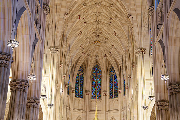 The photo captures a soaring Gothic ceiling with ribbed vaults and decorative bosses. Arched windows and stone columns emphasize the verticality and beauty of the sacred space.