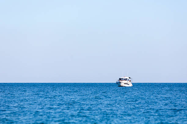 motor boat in the sea. Top view of the boat. Top view of a white boat sailing in the blue sea. A boat with a motor on blue water.